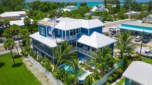 Une maison à deux étages avec un balcon, une piscine et une vue sur l’océan.