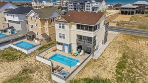 Un edificio residenziale a più piani con piscina, veranda coperta e vista sulla spiaggia.