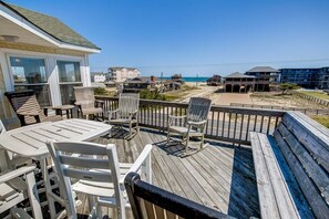 Enjoy a relaxing moment on the deck with comfortable seating and a stunning beach view.
