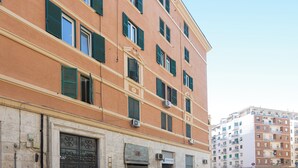 A multi-story building with a beige facade, green shutters, and air conditioning units. - Rental In Rome Sistina View Terrace Apartment (Rome)