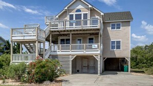 Une maison à deux étages avec un balcon, un garage et une allée couverte.