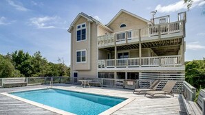 Une maison à deux étages avec une piscine et une terrasse.
