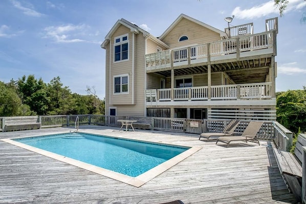 Une maison à deux étages avec une piscine et une terrasse.