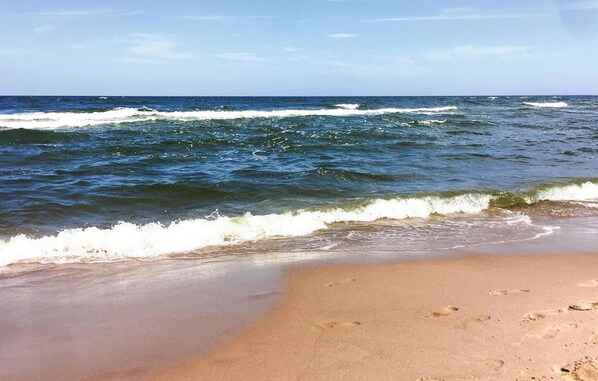 Una playa con olas acercándose a la orilla.