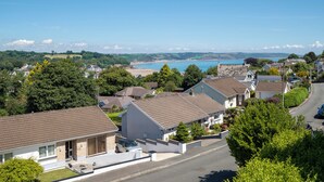A residential area with houses, a road, and a view of the sea.