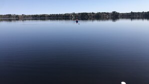 Un lago tranquilo con una persona remando en kayak.