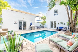 A swimming pool with lounge chairs, a dining area, and a 'NO DIVING' sign.