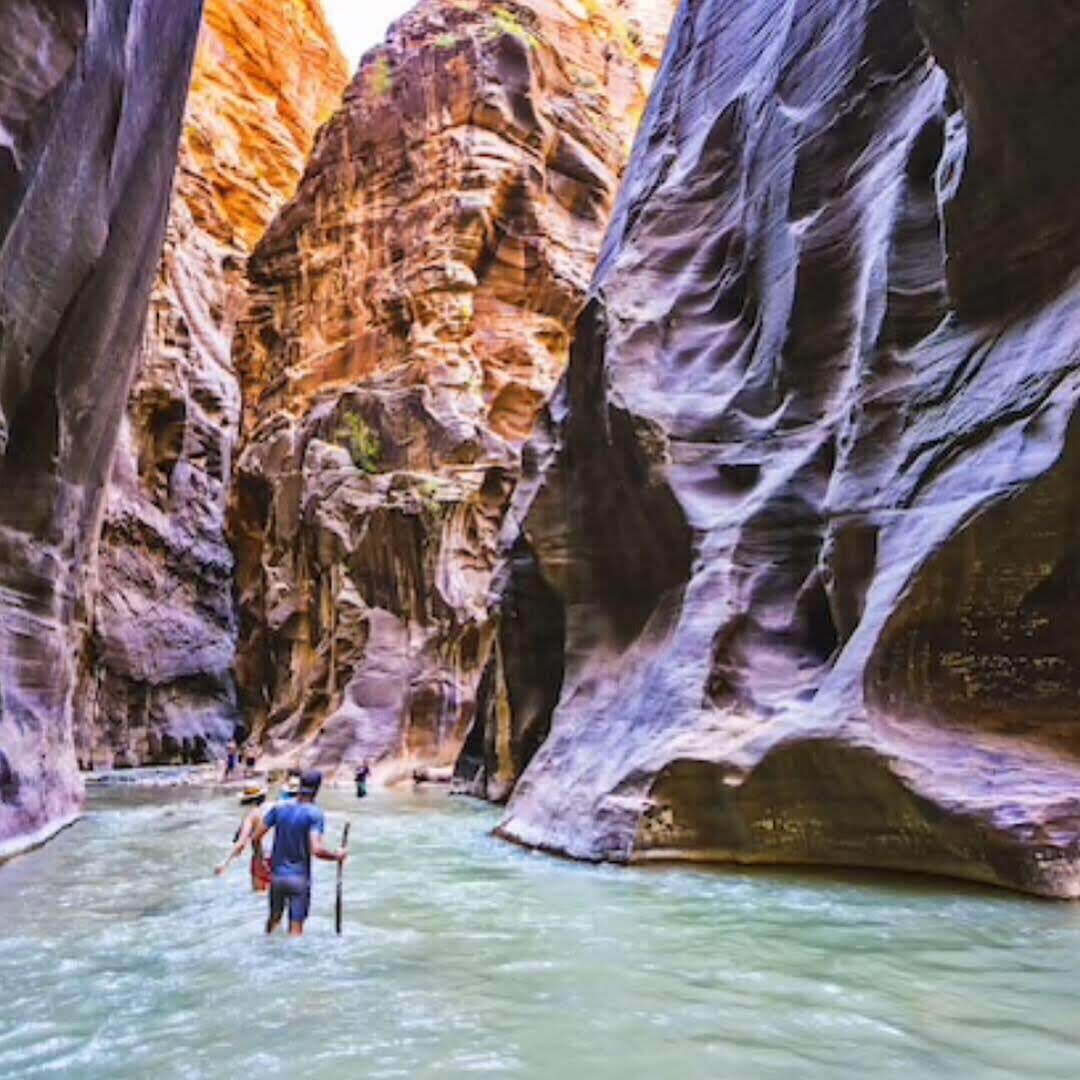 A narrow canyon with a river flowing through it.
