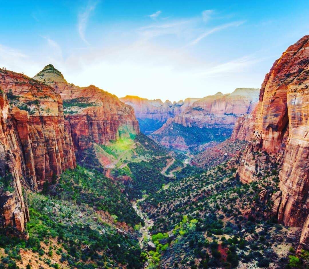 A canyon landscape with steep cliffs and a valley.