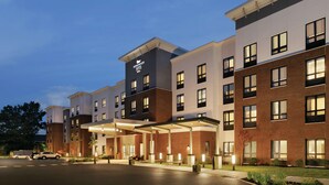 A multi-story hotel with a modern design, featuring a covered outdoor seating area and a well-lit entrance. - Homewood Suites by Hilton Horsham Willow Grove (Horsham)