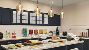 A modern kitchen with marble countertops, dark cabinetry, and pendant lighting. - Homewood Suites by Hilton Horsham Willow Grove (Horsham)