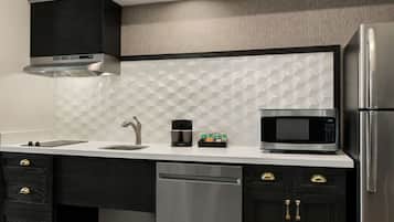 A modern kitchen with a stainless steel refrigerator, microwave, and dishwasher.