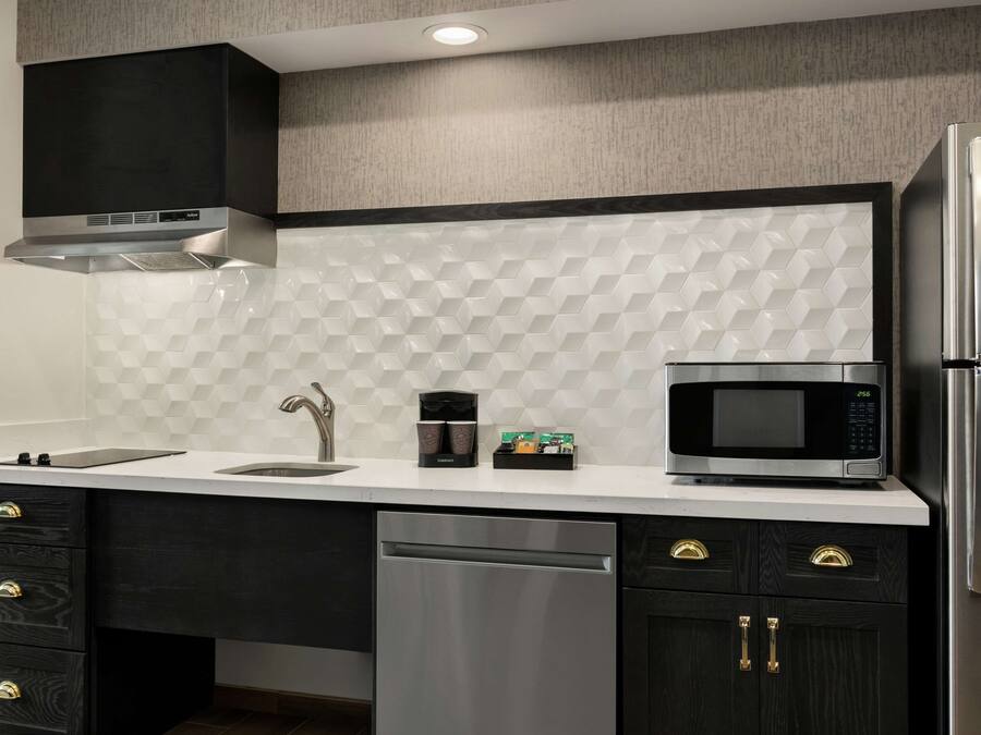 A modern kitchen with a stainless steel refrigerator, microwave, and dishwasher.