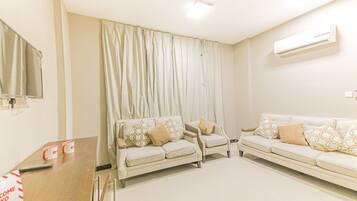 Deluxe Two Bedroom Apartment | Living room | 32-inch flat-screen TV with satellite channels, TV