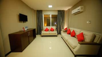 Deluxe Two Bedroom Apartment | Living area | 32-inch flat-screen TV with satellite channels, TV