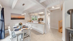 Una cocina moderna con armarios blancos, una isla central e iluminación colgante.