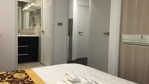 Une chambre d’hôtel avec un lit, une salle de bain avec douche et un miroir.