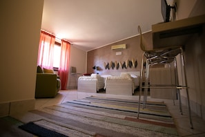 A bedroom with a bed, two bedside tables, a chair, a desk, and a window with curtains. - B&B Trepo (Tropea)