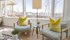 A cozy living room with two armchairs, a side table, and a floor lamp.