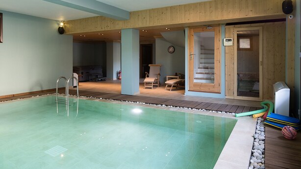 A swimming pool with a wooden deck, lounge chairs, and a sauna. - Alpine Aria (Kalavrita)