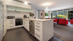 Eine moderne Küche mit weißen Schränken, einem Geschirrspüler und einer Kaffeemaschine.