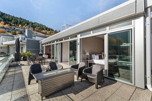 A modern outdoor patio with a dining area, a sofa, and a table. - Edgar Rise, 500m from Queenstown CBD (Queenstown Hill)