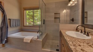 Une salle de bain moderne avec une douche à parois de verre, une baignoire sur pieds et un meuble-lavabo avec un vasque.