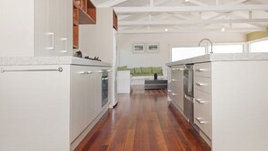 Eine moderne Küche mit weißen Schränken, Holzboden und einem eingebauten Backofen.