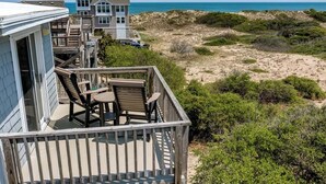 A beachfront property with a wooden deck, outdoor furniture, and a view of the ocean. - Pelican's Perch | 320 ft from the beach | Private Pool, Hot Tub | Corolla (Corolla)