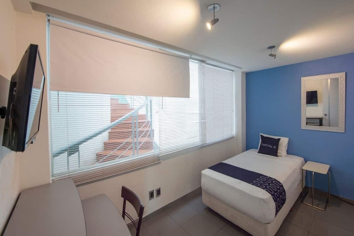 A modern bedroom with a bed, a desk, and a chair.