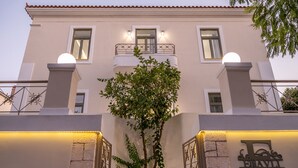 Un edificio con balcón, un árbol en primer plano y un cartel con la letra 'E' y las palabras 'Classic City Hotels'.