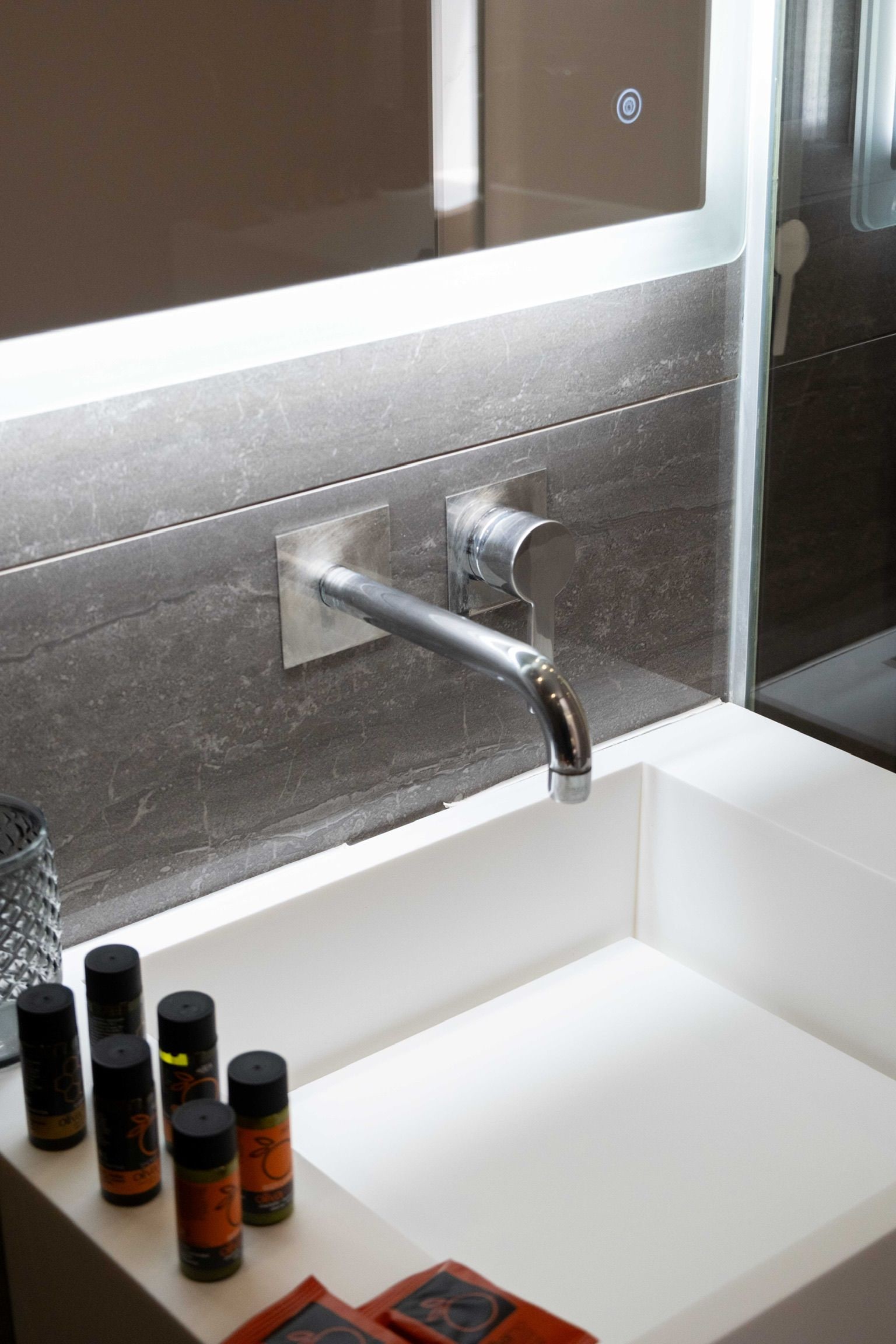 A bathroom with a modern sink, a mirror, and a shower area.