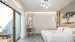 Un dormitorio moderno con cama, escritorio y silla, una puerta corrediza de vidrio a un balcón y un cuadro en la pared.