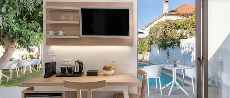 A modern kitchen with a built-in TV, wooden cabinets, and a small fridge.