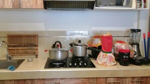 Eine Küche mit Holzausstattung, einer Mikrowelle, einem Herd, einem Backofen und verschiedenen Küchengeräten.