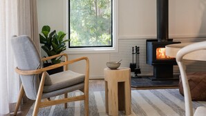 A cozy living room with a wooden chair, a small side table, and a fireplace.