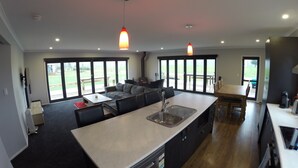 A modern kitchen with a central island, large windows, and a dining area. - Full holiday home to yourself, up to 21 guests (Atiamuri)