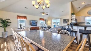 A spacious kitchen with a granite island, white cabinetry, and a ceiling fan. - Sea the Day | 717 ft from the beach | Private Pool, Hot Tub | Nags Head (Nags Head)