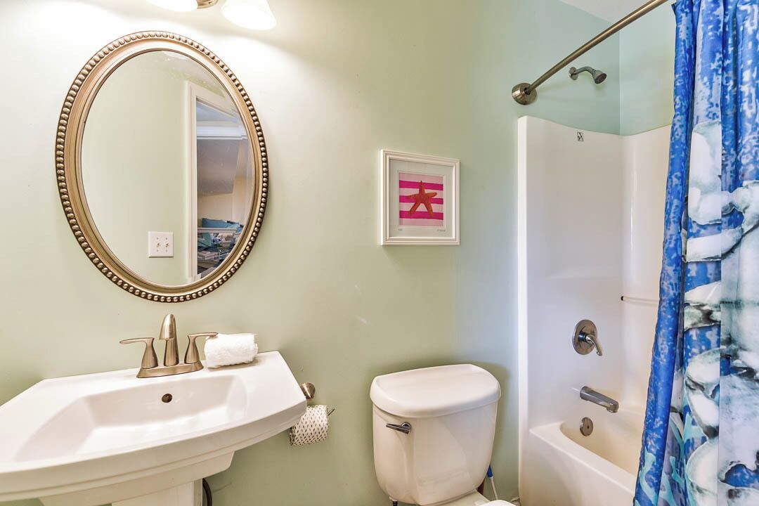 Een badkamer met een wit wastafel, toilet en bad.