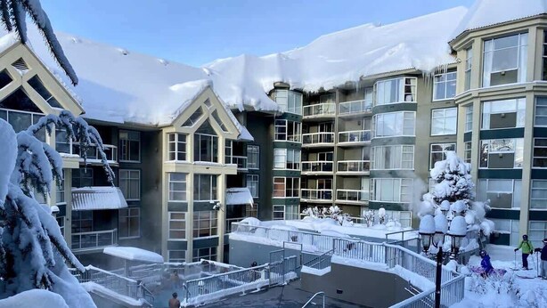 A hotel with a pool area surrounded by snow-covered buildings and trees. - Whistler retreat w/ pool & hot tub (Whistler)