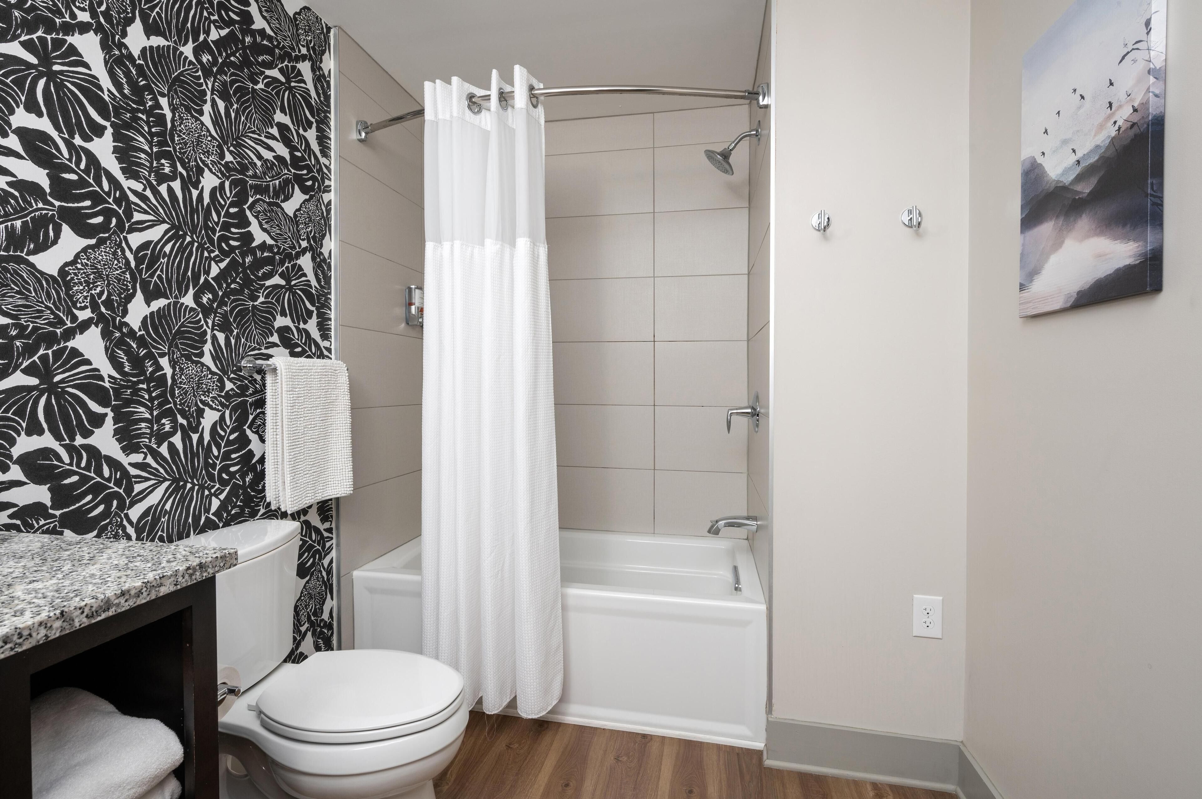 A bathroom with a shower, toilet, and sink.