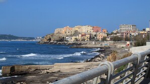 A coastal town with buildings on a cliff overlooking the sea. - B&B Allerìa (Pozzuoli)