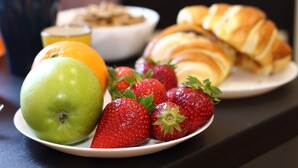 A plate with a green apple, strawberries, and a croissant. - B&B Allerìa (Pozzuoli)