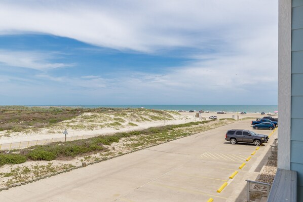 A parking lot with a view of the beach and ocean.