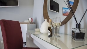 A modern living room with a glass-top table, a white vase, a bottle of champagne, and two champagne glasses. - Vesù (Naples)