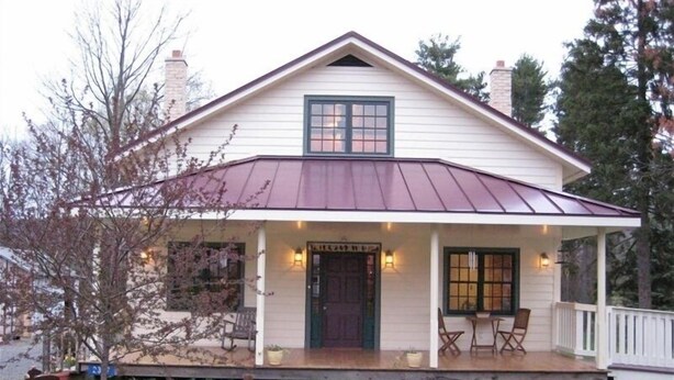 A two-story house with a porch, a front door, and a small garden area. - Rustic Elegance to Feed Your Soul in the Heart of Pennsylvania (Loganton)