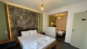 A hotel room with a large bed, a nightstand, a wall-mounted artwork, a bathroom with a mirror and towel rack, and a door with the number 301. - Alada Garden Otel (Bozcaada)