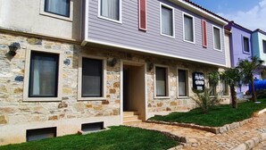 A two-story building with a stone facade and a sign for 'ALFA GARDEN HOTEL'. - Alada Garden Otel (Bozcaada)