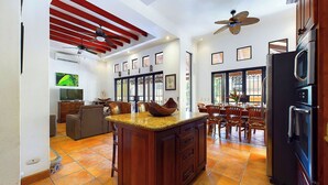Una cocina amplia con una isla central, armarios de madera y un refrigerador negro.
