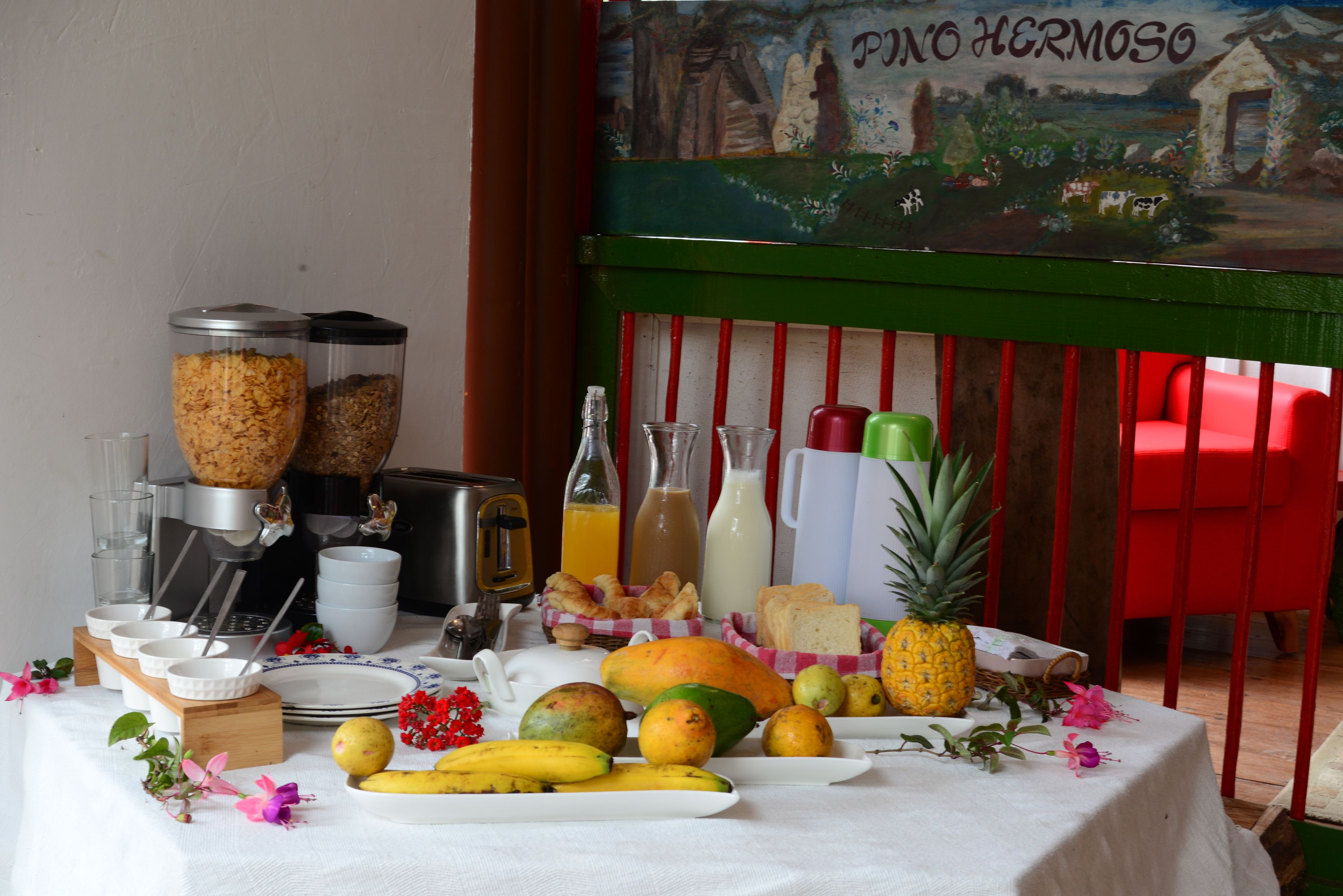 A breakfast table with various fruits, beverages, and breakfast items.